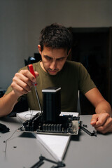 Vertical portrait of technician male installing CPU cooler onto motherboard with screwdriver, conducting maintenance and upgrades on desktop computer for improved performance and efficiency.