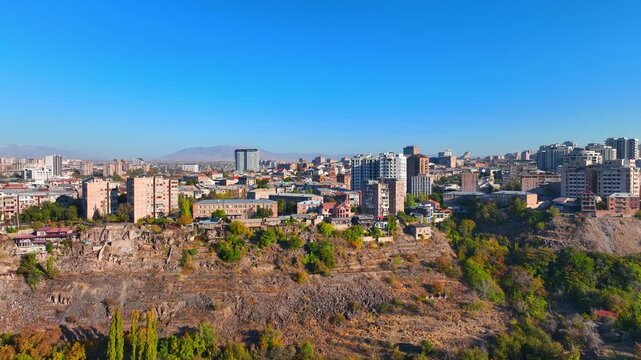 A city with a bridge and a river in the background. The sky is blue and the buildings are brown
