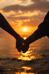 Couple holding hands at sunset on the beach