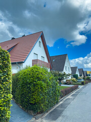 Charming suburban neighborhood with colorful houses, lush greenery, and a bright, inviting sky on a sunny day