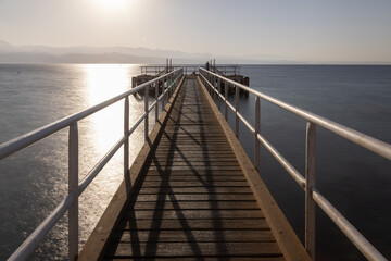 A serene wooden pier stretching into the calm waters of the Red Sea at sunset — a hidden gem on the shores of Eilat, offering peace, beauty, and breathtaking views