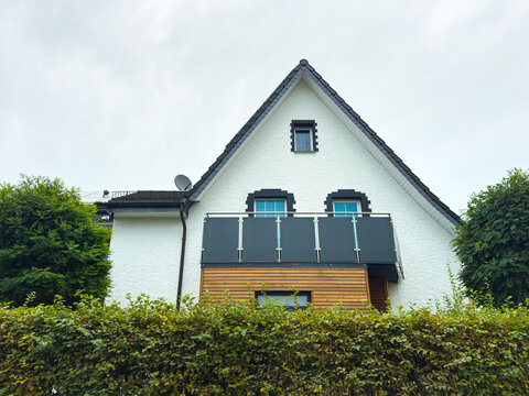 Charming modern house nestled among lush green hedges on a cloudy day