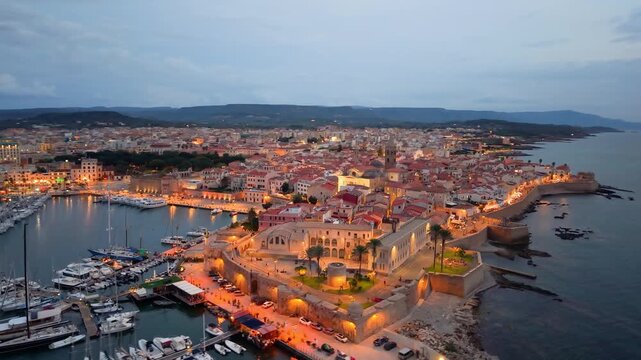 Aerial view of evening seaside fortress, scenic drone footage captures italian coast fortress during sunset evening. Algero