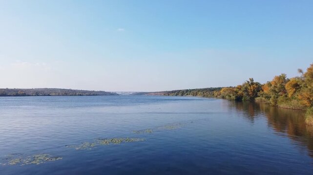 Aerial view of autumn forest and river in Ukraine. Dniepr River and island of Khortytsia. Autumn nature of Eastern Europe. The beauty of Ukraine.