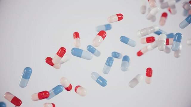 Medical pills and capsules in red, white, and blue color fall in slow motion. Ultra HD 4K 3840x2160 animation for healthcare, pharmaceutical, and science-related topics.