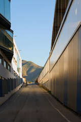 A narrow passage between buildings with a view of the mountains.