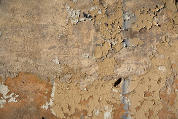 An old painted wall with peeling paint as a background.