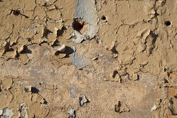 An old painted wall with peeling paint as a background.