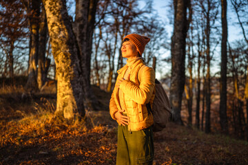 Obraz premium Woman enjoying nature during autumn sunset in forest