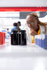 Black pharmacy client searching for over the counter pills and vitamins on stocked retail drugstore shelves, looking for the right remedy to support health and effective pharmaceutical care.