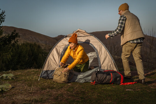 Active couple setting up camping tent for outdoor adventure - Powered by Adobe