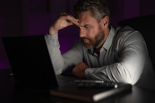Exhausted work. Tired businessman working late at night in a office. Bored exhausted manager using laptop while facing a tight deadline. Exhausted employee. Business man exhausted on late office work. - Powered by Adobe