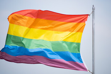 Rainbow flag waving proudly. Pride symbol of equality. Colorful flag in wind. LGBT community support. Freedom and diversity celebration.