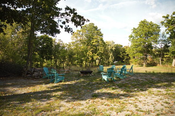 Summer deck chairs around a fire pit. 