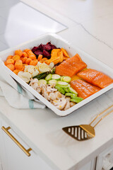 Salmon fillets and fresh colorful vegetables in a baking pan preparing for a healthy sheet pan dinner