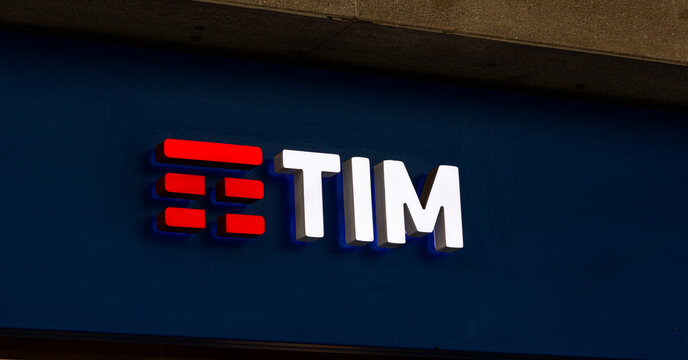 Padova, Italy - April 14, 2025: TIM brand logo illuminated on blue wall, showcasing modern design and vibrant colors, representing telecommunications and digital services in urban environment
