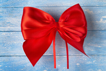 Big red bow on wooden background, top view