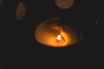 A detailed macro photo of a burning candle flame surrounded by dark, mystic ambience, evoking...