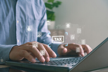 Businessman using laptop for online tax filing and digital financial management. Futuristic icons showing tax, finance and analytics technology concept for business, accounting and data services.