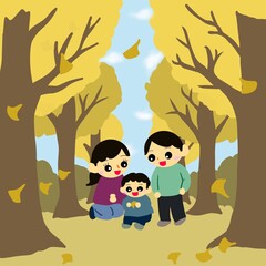 落ち葉が舞う並木道（イチョウ並木）の親子（子どもが落ち葉を拾っている）