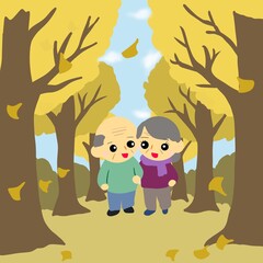 老夫婦が並んで落ち葉が舞う並木道（イチョウ並木）を歩く