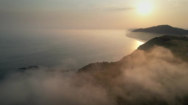 Tripod aerial shot of clouds above Zarautz and Atlantic Ocean at summer sunrise. Gipuzkoa, Basque Country, Spain.