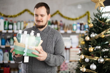 Happy man shopping for Christmas presents at home goods store