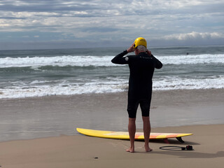 Senior adult Australian man preppers going wave surfing in the Pacific ocean