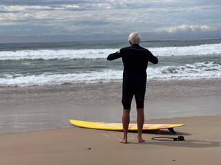 Senior adult Australian man preppers going wave surfing in the Pacific ocean