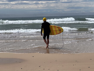 Senior adult Australian man preppers going wave surfing in the Pacific ocean
