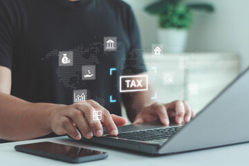 Man using laptop for online tax filing and financial management with futuristic icons of finance, analytics and digital data. Concept for business accounting, fintech and modern tax technology.