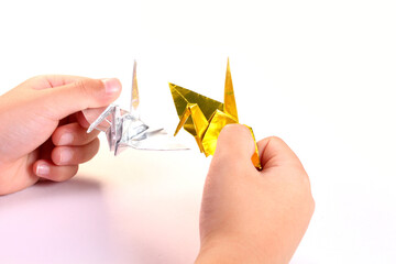折り鶴を持つ子どもの手