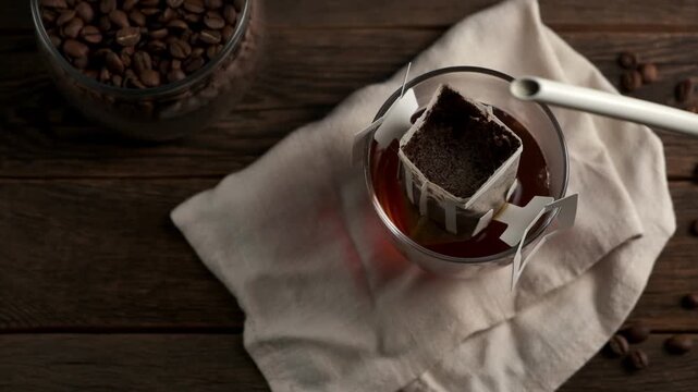 Making coffee with drip coffee bag on a wooden table. Drip brewing coffee.