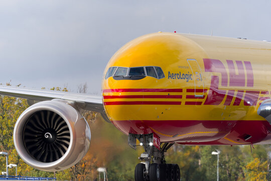 Close-up of yellow and red colored DHL Aviation cargo airplane type Boeing 777F D-AALZ at taxiing at Frankfurt Airport on an autumn day. Photo taken November 3rd, 2025, Frankfurt am Main, Germany.