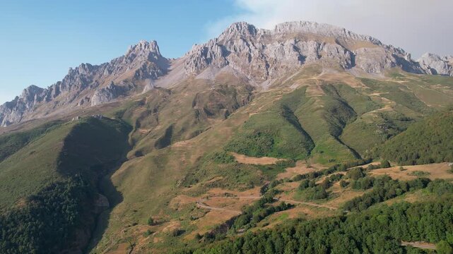 Rising up aerial shot of Picos de Europa on sunny summer evening. Santa Marina de Valdeon, Leon, Spain.