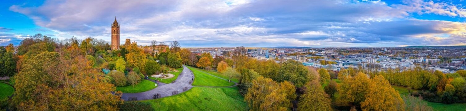 Cabot Tower surrounded by colorful autumn trees in Brandon Hill Park, with historic Bristol architecture in the background.