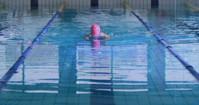 Swimming woman performing breaststroke in pool lane, with pink swim cap and blue lane dividers