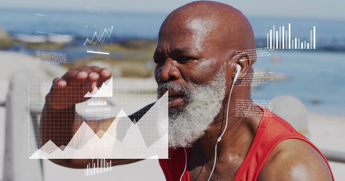 Man wearing red athletic top and earphones analyzing holographic charts on bench by sea