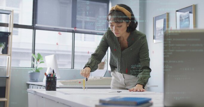 Designer drawing on blueprint with metal compass at design studio, including scale model