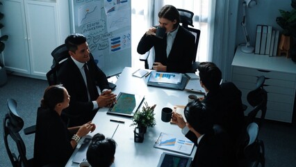 Top view of executive manager looking at financial graph while skilled business team give high five and clapping hands to celebrate increasing sales. Successful team working together. Directorate.