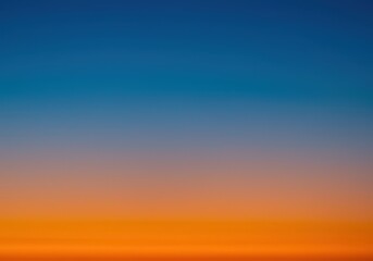 Fototapeta premium Abstract natural sky background with soft gradient colors of sunrise, blending deep blue and vibrant orange hues ,warm ,subtle ,backdrop