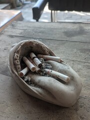 photo of cigarette butts in an ashtray on a table