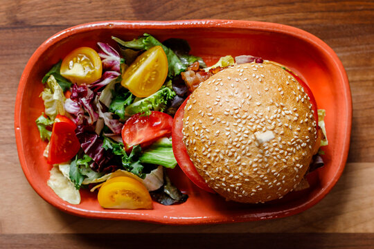 Fresh burger and mixed salad served on a vibrant plate for a delicious meal