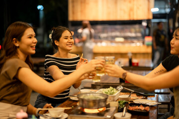 Friends toasting beer celebrating friendship at dinner restaurant