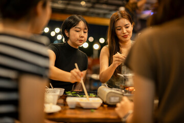 Asian women friends enjoying hot pot dinner together