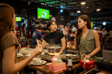 Young asian women friends gathering enjoying hot pot dinner