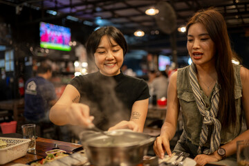 Friends sharing hot pot dinner at asian restaurant