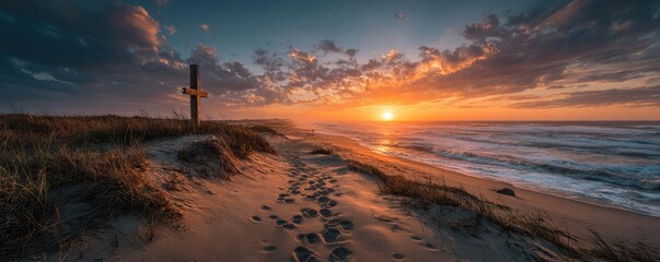 Cross on beach with footprints at sunset concept. Stunning sunset over the ocean with footprints on sandy shore.