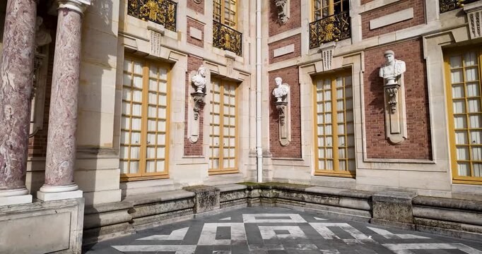 Cinematic 4K low-angle panoramic footage of the Palace of Versailles facade, showcasing textures, materials, sculptures, and architectural details of this iconic French landmark.