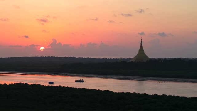 Golden sunset beside Global Vipassana Pagoda and coastal waters in Mumbai. Slow mo pan right